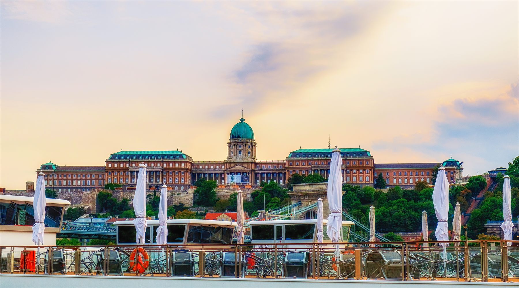 River cruise ship sun deck with folded umbrellas facing Buda Castle, Budapest
